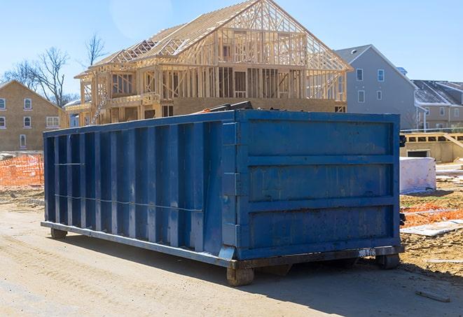 a roll-off residential dumpster in front of a demolition site